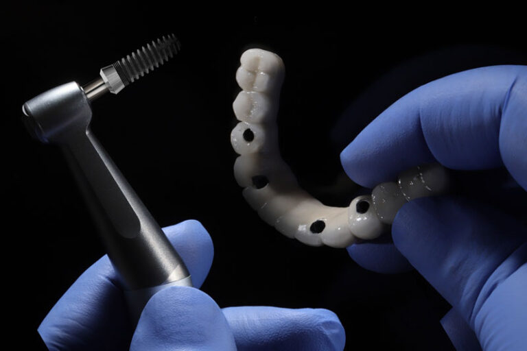 a full arch of teeth with 4 holes for implants to be placed